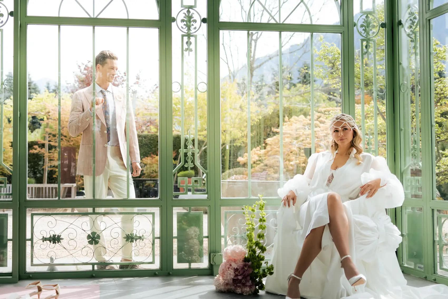 Sposi in una serra liberty dalle vetrate verdi, la sposa seduta in poltrona bianca
